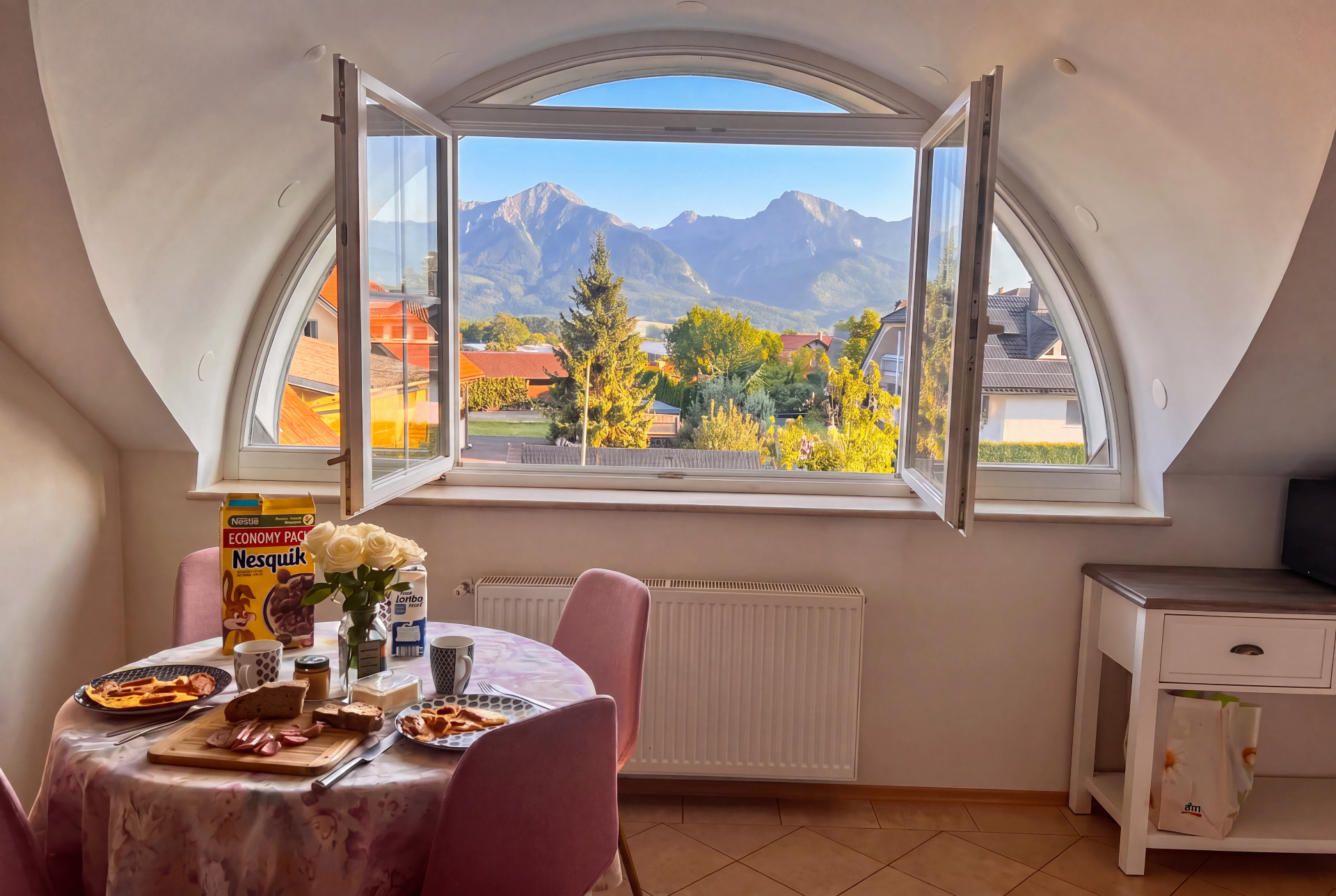 Dining area with open arched window framing the mountains